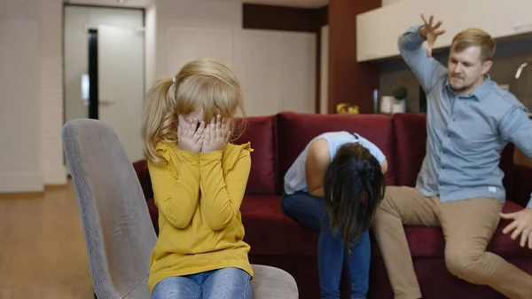 Dziecko dziewczynka cierpi i płacze z powodu kłótni między rodzicami w rodzinie. Konflikt, problemy — Zdjęcie stockowe
