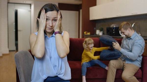 Усталая депрессивная молодая кавказская мать женщина чувствует себя очень раздраженной активным отцом и дочерью ребенка