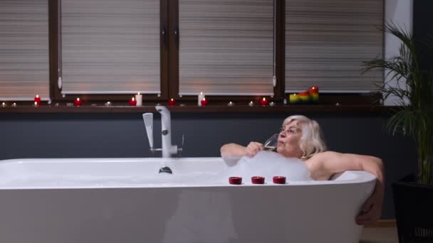 Anziani anziani sdraiati in bagno caldo con bolle, godendo di relax, bere champagne — Video Stock