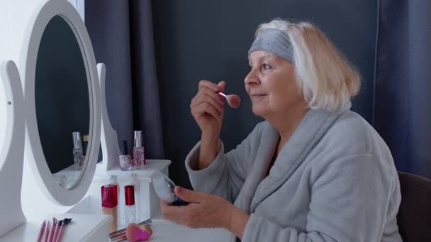 Abuela anciana anciana cuidando la piel, aplicando polvo de base antiarrugas con cepillo — Vídeos de Stock