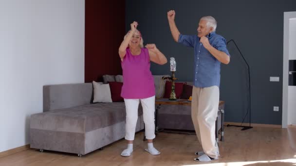 Coronavirus karantinası sırasında evdeki odada dans eden yaşlı çift. — Stok video