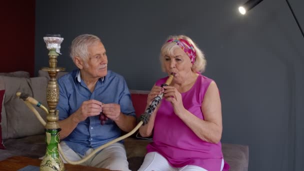 Snygga äldre par njuta av att röka hookah, äta frukt hemma, fira, ha kul tillsammans — Stockvideo