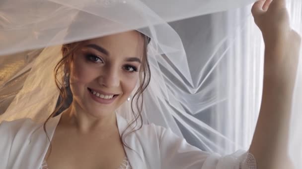 ベールとシルクのローブの下にブドワールのドレスで花嫁。式前の結婚式の朝の準備 — ストック動画