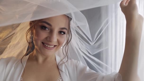 Sposa in abito boudoir sotto il velo e in una veste di seta. Preparativi del mattino di nozze prima della cerimonia — Video Stock