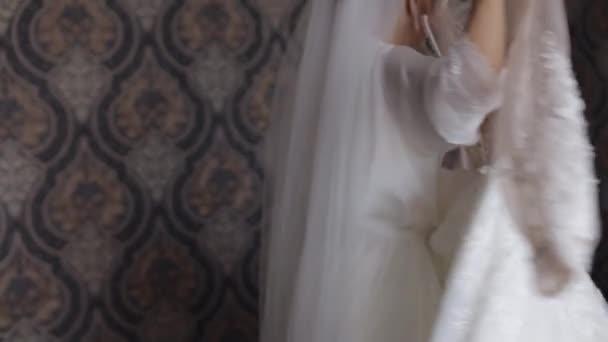 Bruid in lingerie draait in dans met haar trouwjurk. Witte boudoir jurk en sluier — Stockvideo