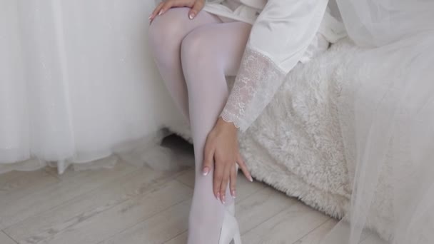 Woman put on wearing wedding shoes. Bridal footwear, morning dressing before ceremony. Slim legs — Stock Video