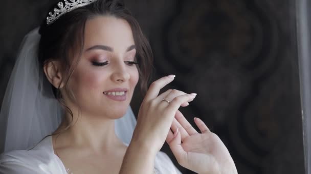 Sposa in abito boudoir vicino alla finestra. Preparativi per il matrimonio. Donna in abito da notte e velo — Video Stock