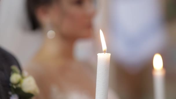 Pasgetrouwden. Bruid en bruidegom staan in de kerk, met kaarsen in hun handen. Bruiloft ceremonie — Stockvideo