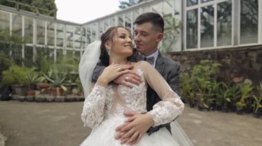 Yeni evliler. Gelin ile beyaz damat parkta yürüyor, sarılıyor, sarılıyor. Düğün çifti