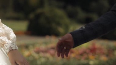 Yeni evliler. Gelinle damadın elleri birbirine dokunur. Parktaki düğün çifti. Mutlu aile