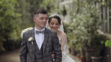 Yeni evliler. Gelin ile beyaz damat parkta yürüyor, sarılıyor, sarılıyor. Düğün çifti