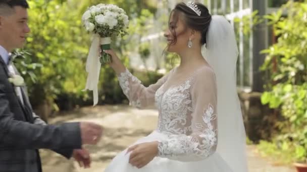 Sposi novelli. Sposo caucasico con sposa che cammina, abbraccia, abbraccia nel parco. Matrimonio coppia — Video Stock