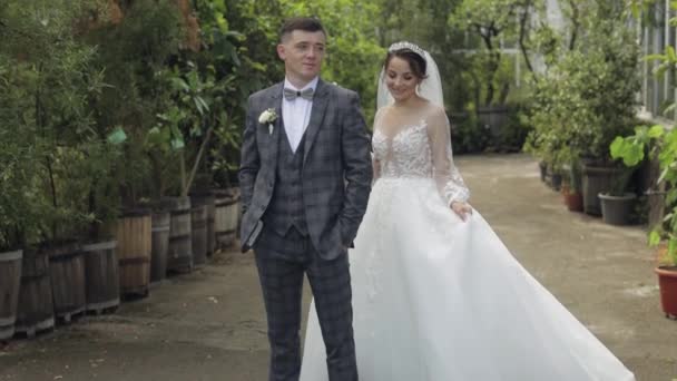 Recién casados. novio caucásico con novia caminando en el parque. Pareja de bodas. Hombre y mujer enamorados — Vídeos de Stock