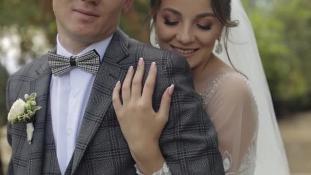 Recém-casados. Noivo caucasiano com noiva andando, abraçando, abraços no parque. Casamento casal — Vídeo de Stock