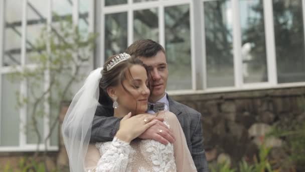 Nygifta. Vit brudgum med brud promenader, omfamning, kramar i parken. Bröllopspar — Stockvideo