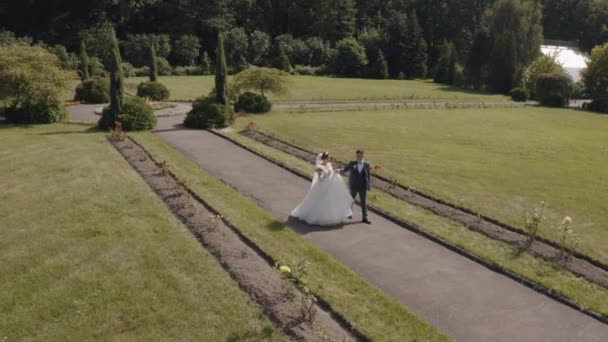 Pengantin baru. Pengantin pria kaukasia dengan pengantin membuat ciuman di taman. Pasangan pernikahan. Pria dan wanita jatuh cinta — Stok Video