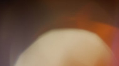 Işık sızıntısı 4K görüntüsü. Lens parlaklığı bokeh örtüleri, yanan alev arka planı. Flaş ışınları etkisi