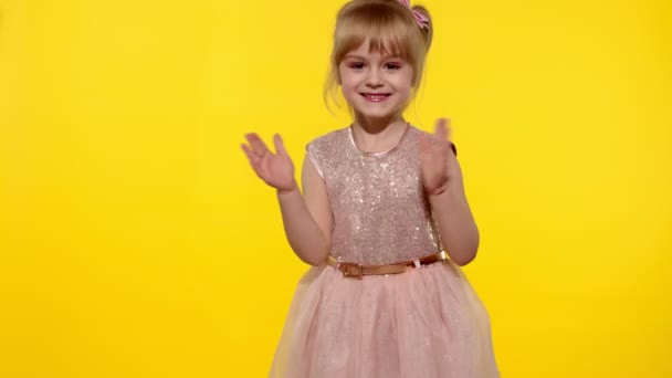 Malá blondýnka dítě dívka 5-6 let s úsměvem, tanec, slaví na žlutém pozadí studia — Stock video