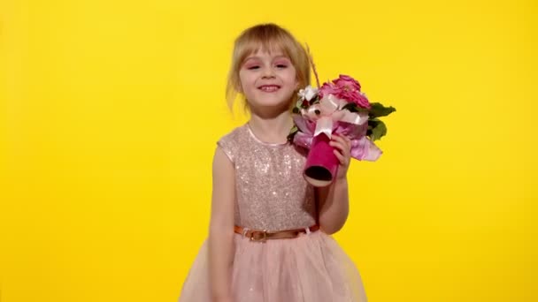 Menina pequena com maquiagem de moda de pé com buquê de flores isoladas no fundo amarelo — Vídeo de Stock