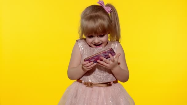Flicka som använder smartphone. Barn sms:ar på smartphone. Kid spelar spel på mobiltelefon i studio — Stockvideo