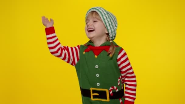 Flicka i tomtenisse Santa hjälpreda kostym vinka hälsning med handen. Hej, hej, hälsningar gest — Stockvideo