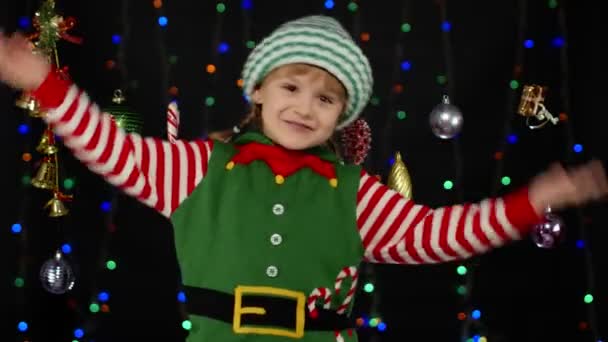 Menina no duende de Natal Santa ajudante de traje dançando, brincando. Celebração do feriado de Ano Novo — Vídeo de Stock