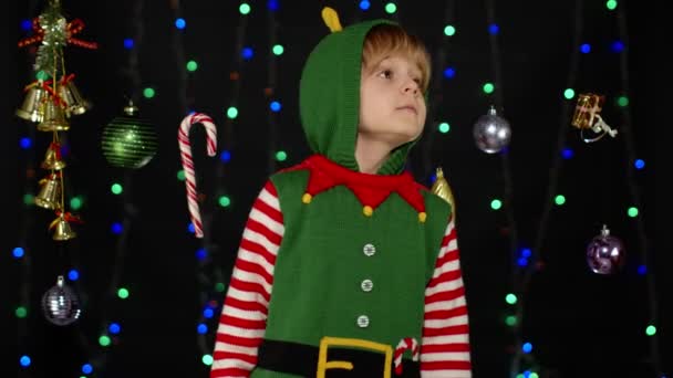 Gyerek lány karácsonyi manó Mikulás segítő jelmez tartja ujját közel ajkak a csend, csend jel — Stock videók