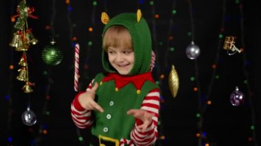 Noel Elf Noel Baba kostümlü çocuk dans ediyor, oynaşıyor. Yeni yıl bayramı kutlaması
