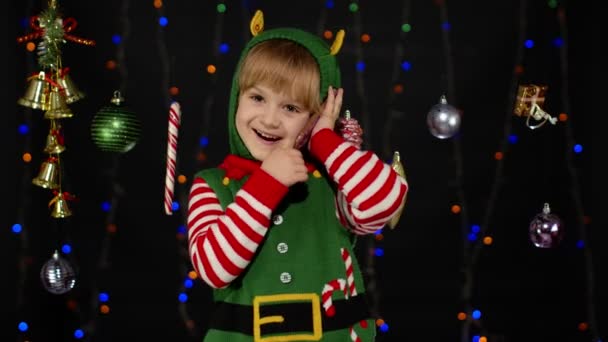 Niña en Navidad elfo Santa Claus ayudante traje haciendo felicitaciones llamada en el teléfono móvil — Vídeos de Stock