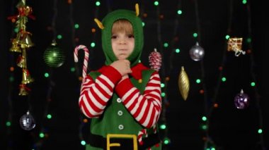Noel Elf Noel Baba kostümlü çocuk dans ediyor, oynaşıyor. Yeni yıl bayramı kutlaması
