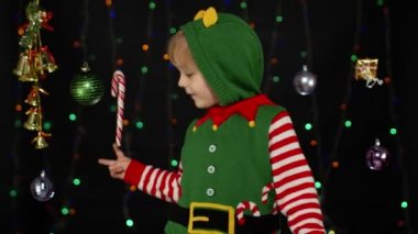 Noel Elf Noel Baba kostümlü çocuk dans ediyor, oynaşıyor. Yeni yıl bayramı kutlaması