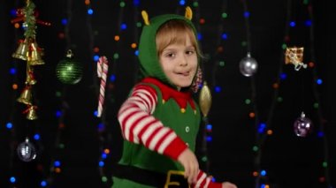 Noel Elf Noel Baba kostümlü çocuk dans ediyor, oynaşıyor. Yeni yıl bayramı kutlaması