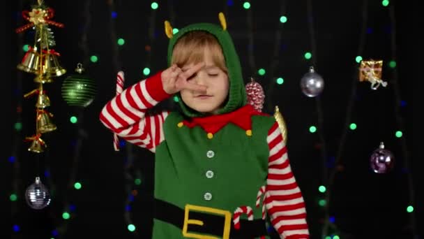 Mädchen im Weihnachtselfen-Helferkostüm tanzt und albert herum. Neujahrsfeier — Stockvideo