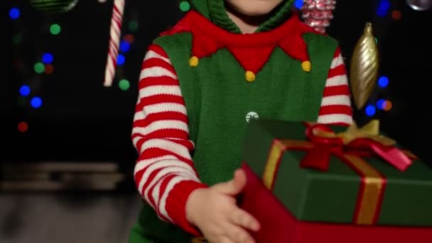 Kid meisje in kerst elf Kerstman helper kostuum krijgen, het ontvangen van verrassing geschenkdoos, geluk — Stockvideo