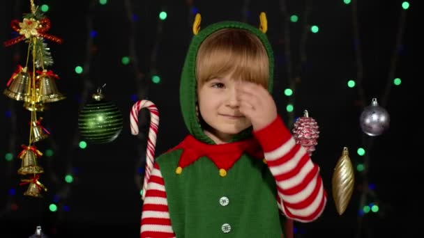 Mädchen im Weihnachtselfen-Helferkostüm winken mit der Hand. Hallo, hallo, Grußgeste — Stockvideo