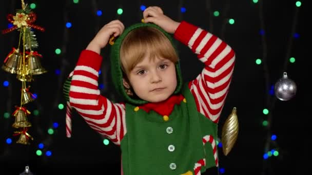 Девочка в костюме помощника рождественского эльфа Санты танцует, валяет дурака. Празднование Нового года — стоковое видео