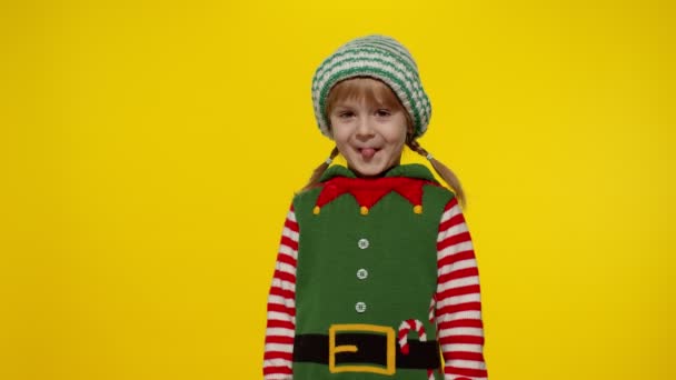 Dziecko dziewczyna w Boże Narodzenie elf Mikołaj pomocnik kostium robi gest zwycięzca, świętowanie. Nowy Rok urlopu — Wideo stockowe