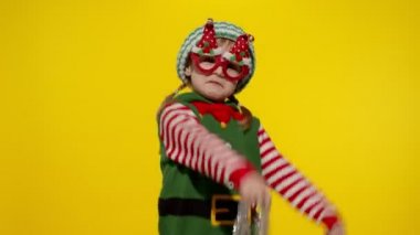 Noel Elf Noel Baba kostümlü çocuk dans ediyor, oynaşıyor. Yeni yıl bayramı kutlaması