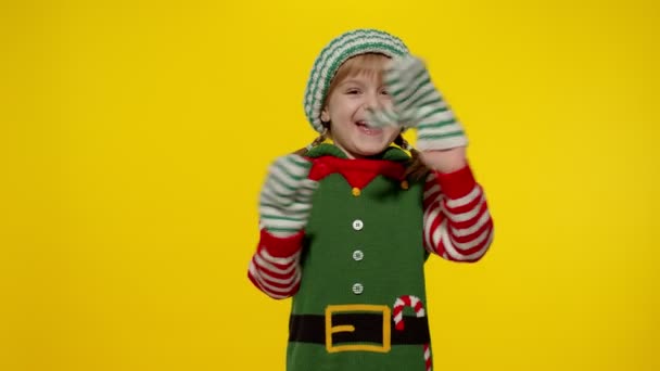 Mädchen im Weihnachtselfen-Helferkostüm winken mit der Hand. Hallo, hallo, Grußgeste — Stockvideo