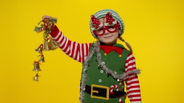 Kind kind meisje in kerst elf Kerstman helper kostuum vasthouden en rinkelen klokken speelgoed. Nieuwjaarsvakantie — Stockvideo