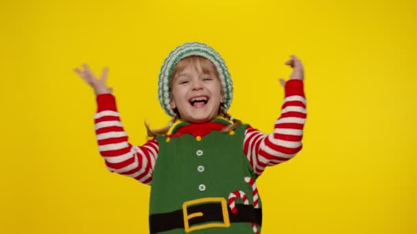 Dziecko dziewczyna dziecko w Boże Narodzenie elf Mikołaj pomocnik kostium pokazując kciuki w górę gest. Nowy Rok urlopu — Wideo stockowe