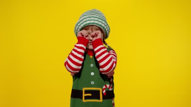Karácsonyi manó jelmezes kislány sír és könnyeket töröl. Újévi ünnepség — Stock videók