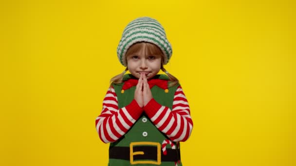 Niño en Navidad elfo Santa ayudante traje ruega, reza por los regalos en Año Nuevo. Mantiene las palmas juntas — Vídeos de Stock