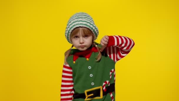 Displesed dziecko dziewczyna w Boże Narodzenie elf pomocnik kostium trzyma kciuk w dół i pokazuje niechęć do gestu — Wideo stockowe