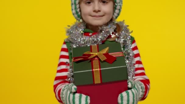 子供の女の子クリスマスエルフサンタヘルパーは、カメラにプレゼントボックスを与えます。明けましておめでとうございます。 — ストック動画