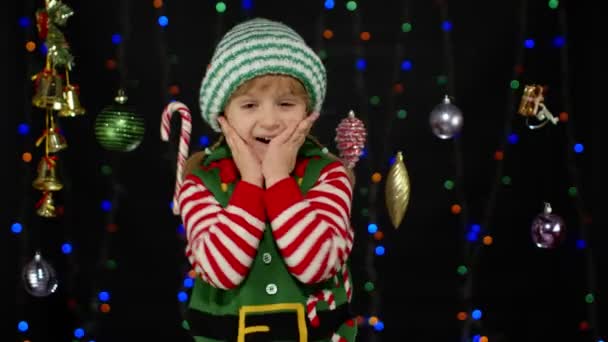 Excited kid girl in Christmas elf Santa Claus helper costume. Child doing winner gesture, say Yes — Stock Video