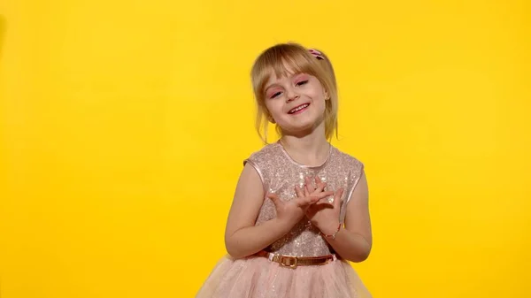 Pequeña niña rubia sonriente posando sobre fondo amarillo. Lugar para texto, logotipo o producto —  Fotos de Stock