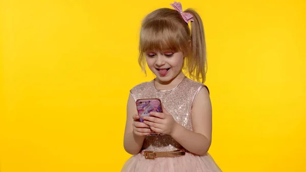 Akıllı telefon kullanan bir kız. Akıllı telefondan mesajlaşan çocuk. Stüdyoda cep telefonuyla oyun oynayan çocuk. — Stok fotoğraf