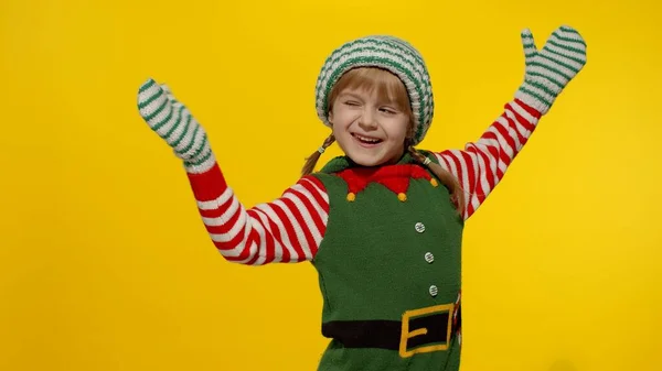 Kid girl in Christmas elf Santa helper costume dancing, fooling around. New Year holiday celebration — Stock Photo, Image