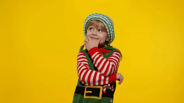 Christmas wish concept. Kid teen girl in Christmas elf Santa helper costume making a wish, prays